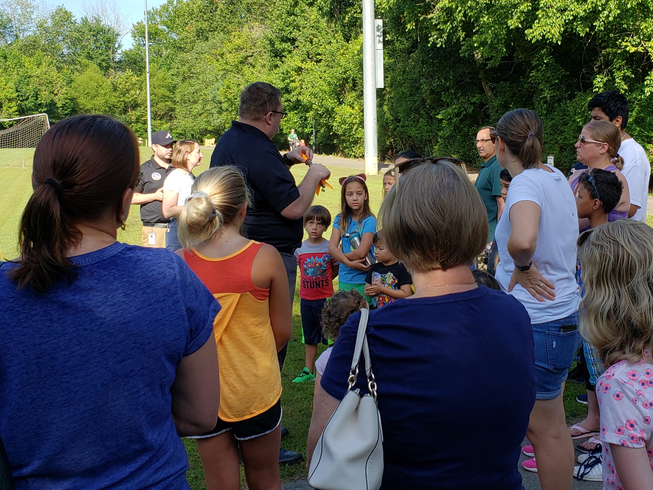 Maj. Johnston helps students with a rocket launch in Sugar Hill, Georgia as students and parents look on
