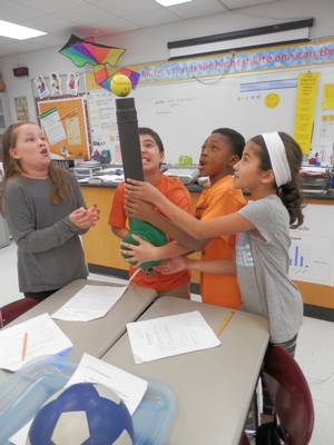 Classroom students demonstrating with Bernoulli's principle with tennis ball