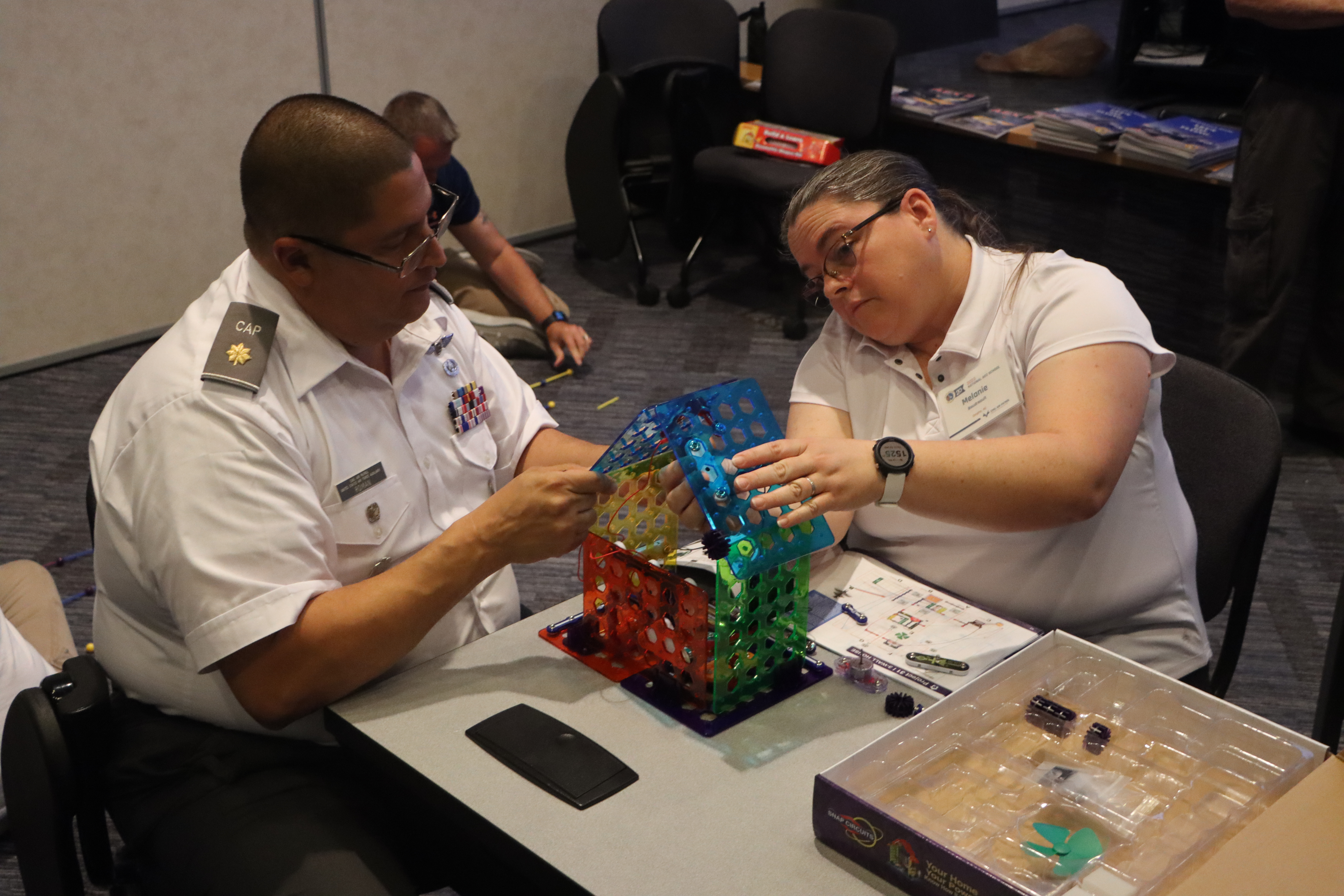 Maj Roman works on the electricity STEM kit with another AEO school participant