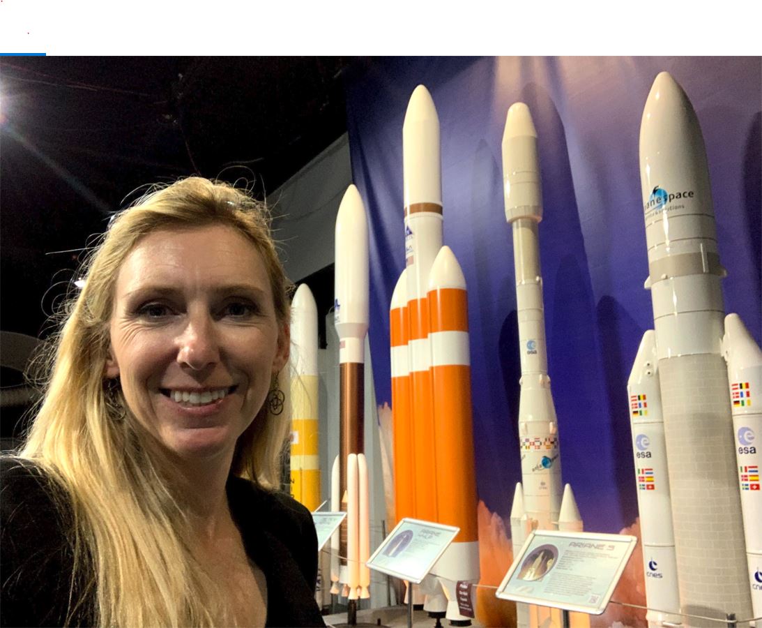 Kaci Heins poses in front of Rocket display