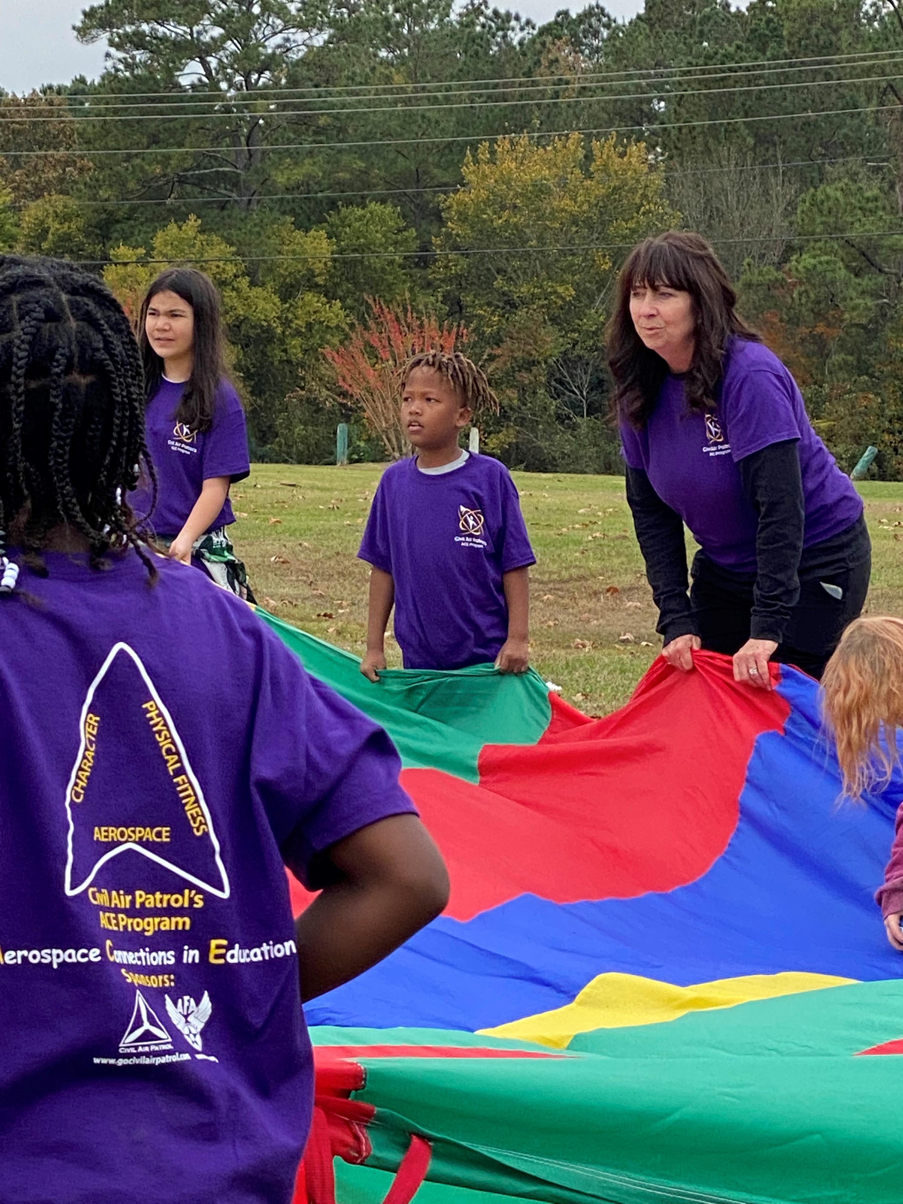 Melanie Justice and students work with a parachute